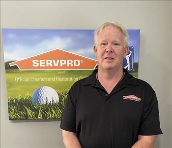 SERVPRO male employee Chip Copas is shown standing in front of logo 